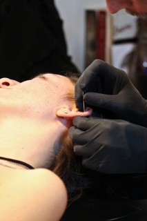 A customer gets an ear cartilage piercing at Mom’s Body Shop on Haight Street in San Francisco.
