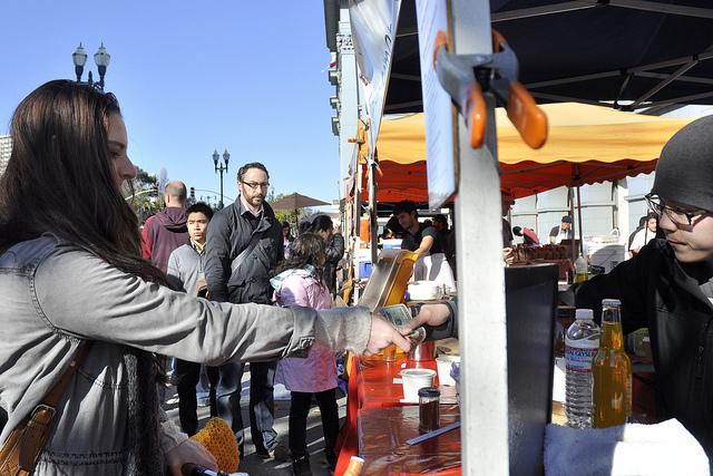 A customer pays for her meal at Hapa Ramen at the Embarcadero Farmer's Market in San Francisco on Thursday, Dec 13, 2012. Hapa Ramen sells their food at the farmers market Tuesdays and Thursdays from 10 a.m. to 2 p.m. Photo by Godofredo Vasquez/Xpress