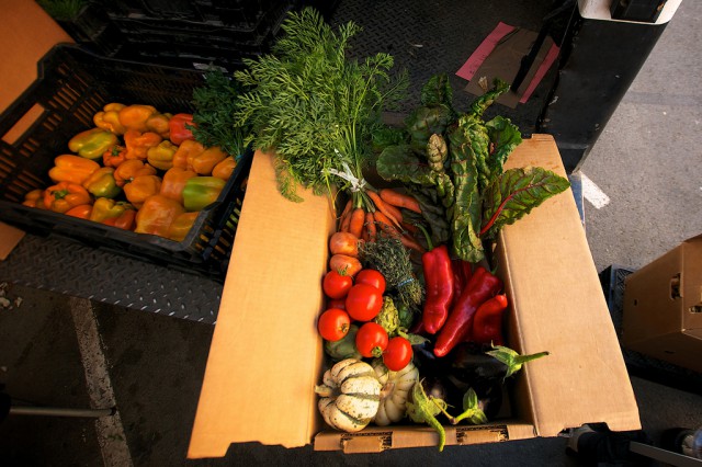 An example CSA subscription box, put together by Blue House Farms, sits on the back of their truck during a farmers market event in the Mission District. Photo by Kate ONeal / Xpress.