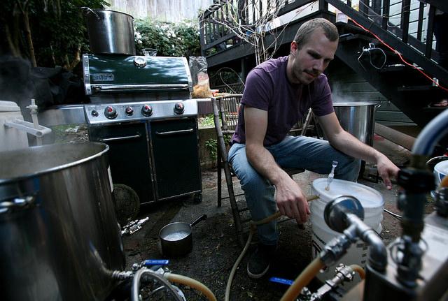 Paul Tiplady, one out of four guys in Method Brewing, keeps an eye on the water pump and plate chiller as they transfer and cool the beer into buckets right before adding the yeast as they were making a few batches of beer in San Francisco Sunday, Feb. 22.