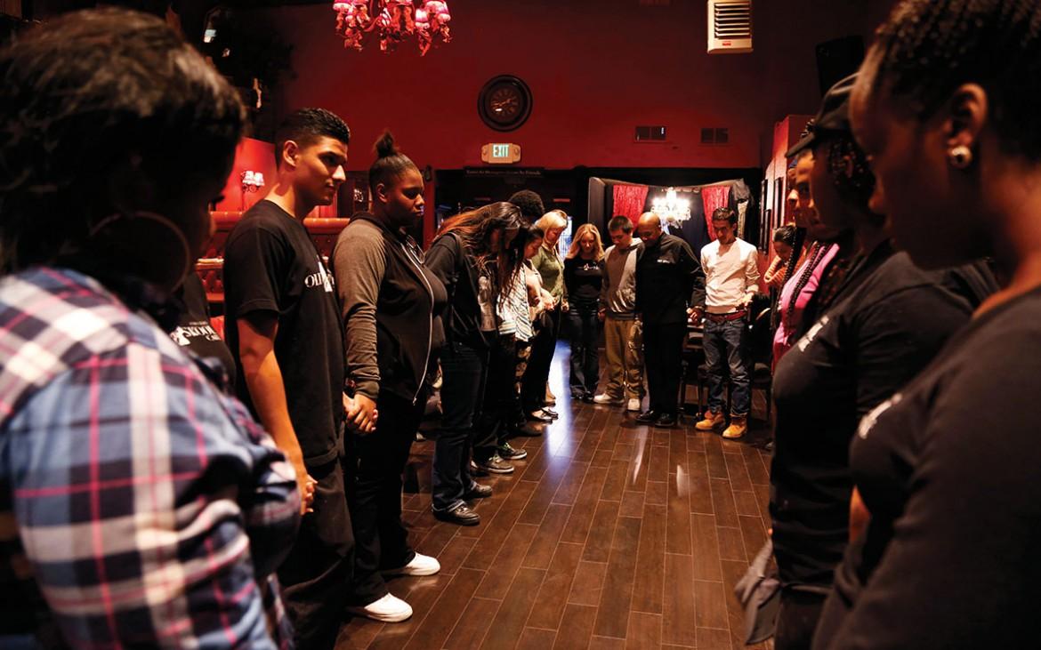 Youth employed at Old Skool Cafe, a faith-based violence prevention program that provides employment and restaurant skills to youth ages 16-22, say a blessing over their dinner service Thursday Nov. 5, 2015. Old Skool Cafe is located in the Bayview Hunters Point neighborhood of San Francisco. Photo by Emma Chiang