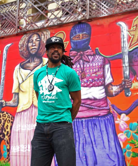 Khafre Jay, the founder and excutive director of Hip Hop for Change, poses for a portrait photo in front of the mural of HipHopForChange Inc. at Oakland, San Francisco, CA. on Tuesday, Sept. 13, 2016. (Perng-chih Huang/Xpress)