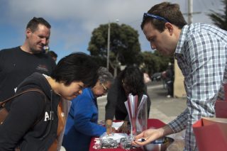 SFMTA Principal Planner Graham Satterwhite (right) and his team work a booth to collect resdients' suggestions for future subway routes in the Excelsior neighborhood of San Francisco on Wednesday, Aug. 31, 2016. Their goal is to reach out to non-English speaking residents, whom otherwise may be left out of this process. (Kin Lee/Xpress)