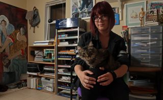 Amanda Campbell with her cat, Skiddy, in her home studio. Amanda adopted Skiddy as a therapy animal and helps her cope with her depression and anxiety. Aleah Fajardo/ Xpress