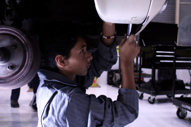 Edwin, 13 works on removing the fender of a car for Project Wreckless, a development program for “at risk” youth in San Francisco, Calif. on March 9, 2018.