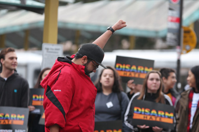 Cinema major Alfredo Lopez holds his fist in protest as part of the national walkout at SF State on Wednesday, March 14, in memory of the 17 victims from the Parkland high school shooting last month. (Christian Urrutia/Xpress)