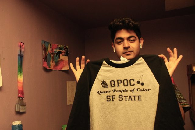 Ashesh Arora, the Director of Events for the Queer Alliance, holds the new shirt for Queer People of Color.