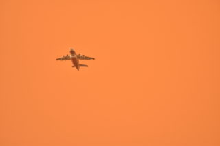 A fire-fighting airtanker flies through a smoke-filled sky as it battles the Carr Fire in Redding, California on July 27, 2018. (Boone Ashworth/Xpress)