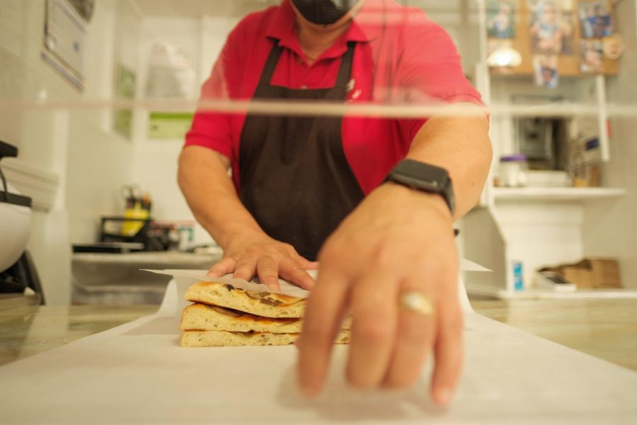 Michael Soracco wraps an order of Focaccia in parchment paper at Liguria Bakery on Thursday, Oct. 7, 2021 in San Francisco, Calif. (Cameron Lee / Xpress Magazine)