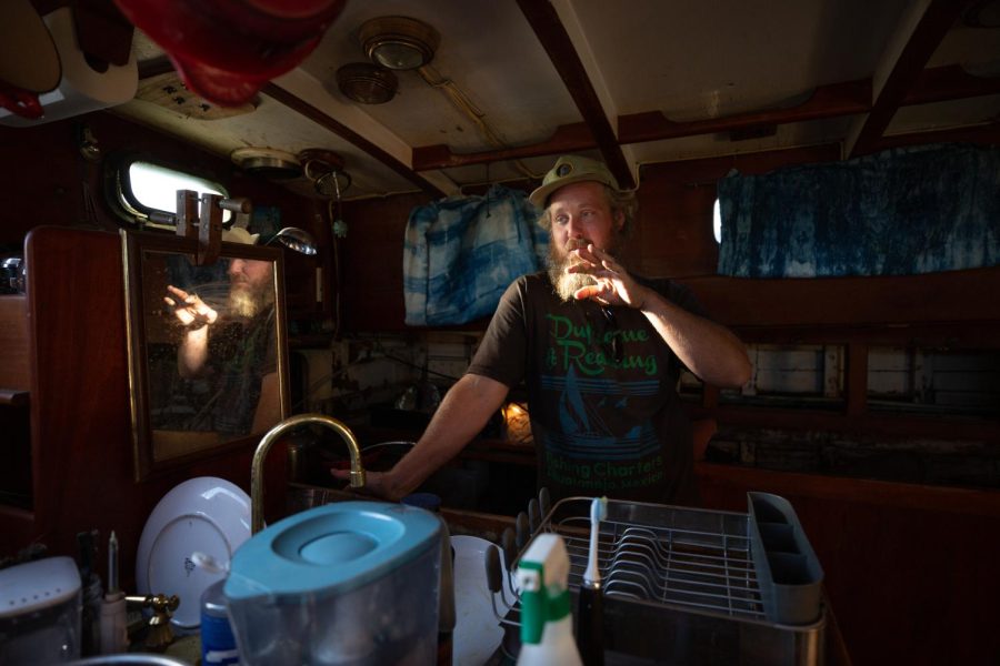 : John Fredericks stands in the galley of the 1973 Porpoise Ketch sailboat that he currently lives in and co-owns with two friends on Nov. 17, 2021. He’s been working on renovating a 32-foot Chesapeake sailboat which he hopes to sail away for good. (Saskia Hatvany/Xpress Magazine) 
