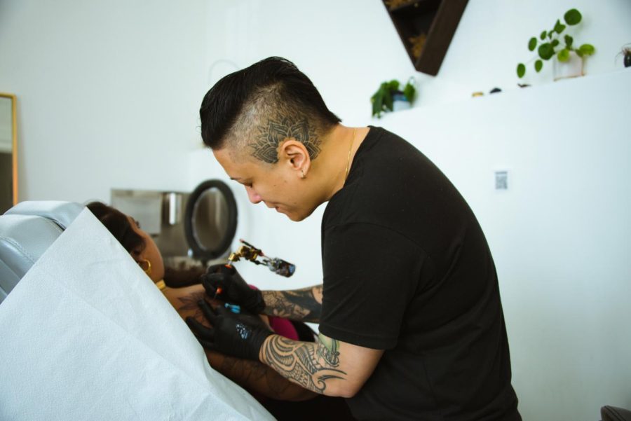 Owner of Gold Leaf Ink, Regina “Push” Estrada, tattoos her apprentice at her studio on Feb. 10, 2022. (Garrett Isley / Xpress Magazine)