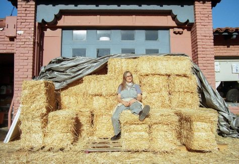 Novella Carpenter, co-founder and co-owner of the BioFuel Oasis Cooperative in Berkeley, poses for a portrait on the stacks of hay behind the store Feb. 5, 2022. (Morgan Ellis / Xpress Magazine)