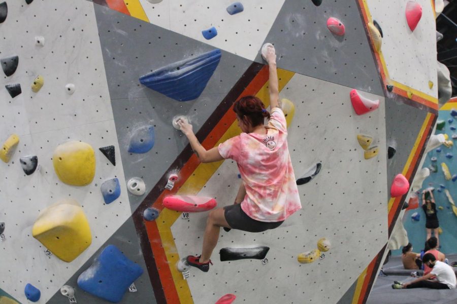 Claire Miller climbs a rock climbing wall at Pacific Pipe Climbing in Oakland, Calif, on October 11, 2022. (Destiny Walker/Xpress Magazine)