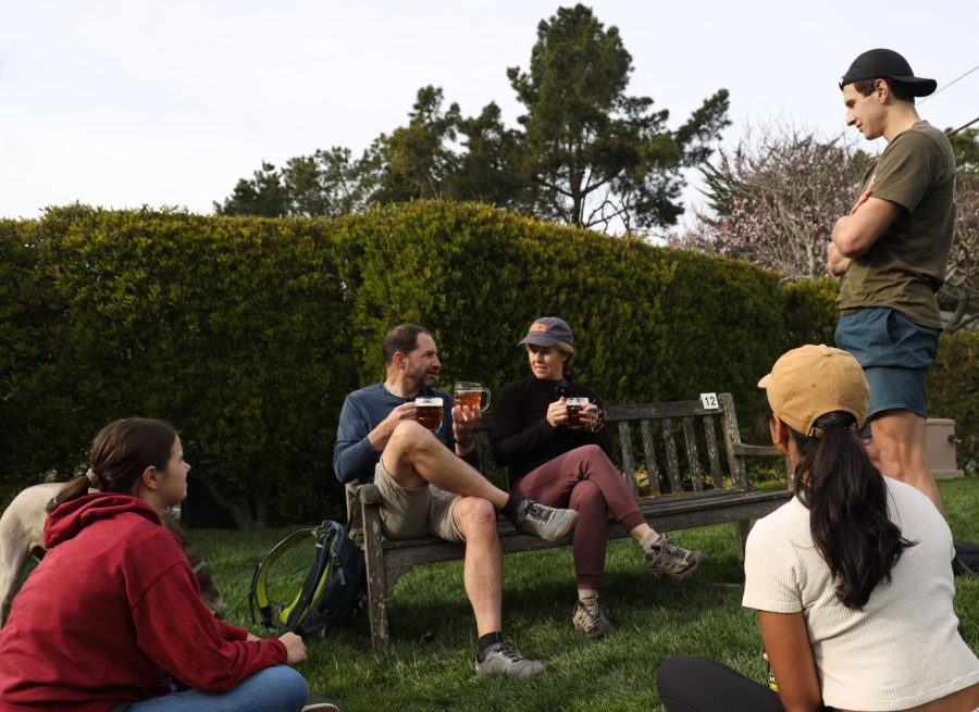 Brenden (L) and Melissa Gingrich (R) enjoy craft beers and cider from the bar as they sit on a bench on the front lawn of Pelican Inn in Muir Beach, Ca. on Feb. 18, 2023. (Tam Vu / Xpress Magazine)