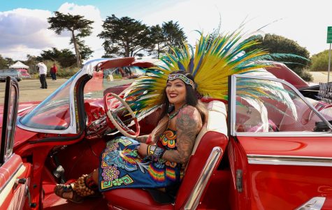 Angelica Mendez sits in a 1960 Chevy Impala in San Francisco in traditional Aztec attire. Mendez was one of the dancers who preformed La Bendición, a blessing to the cars to have a safe cruising season. La Bendición was the first event of the lowrider season, organized by the San Francisco Lowrider Council. (Gina Castro/Xpress Magazine)