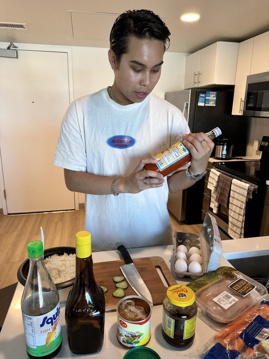 Surat Ebata, a freshman political science major from New Zealand, prepares Thai food. (Feven Mamo - Oct. 9, 2023 / Xpress Magazine)