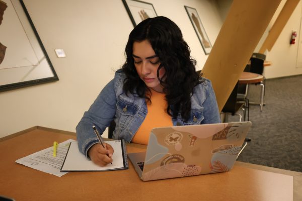 Yeida Elias Sandoval, a third-year student majoring in criminal justice with a minor inLatino studies and sociology, resumes her midterm preparation by consulting her notesafter a brief mental break, on oct. 31, 2023.(Feven Mamo/Xpress Magazine)