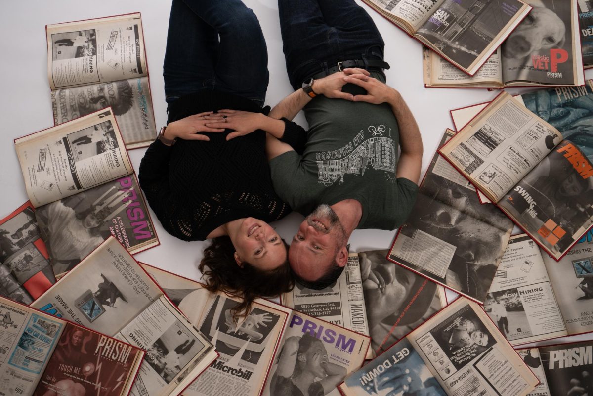 Erin Lubin and Jakub Mosur, former photo editors and photographers for Prism, the predecessor to Xpress, pose with archival copies of Prism. 