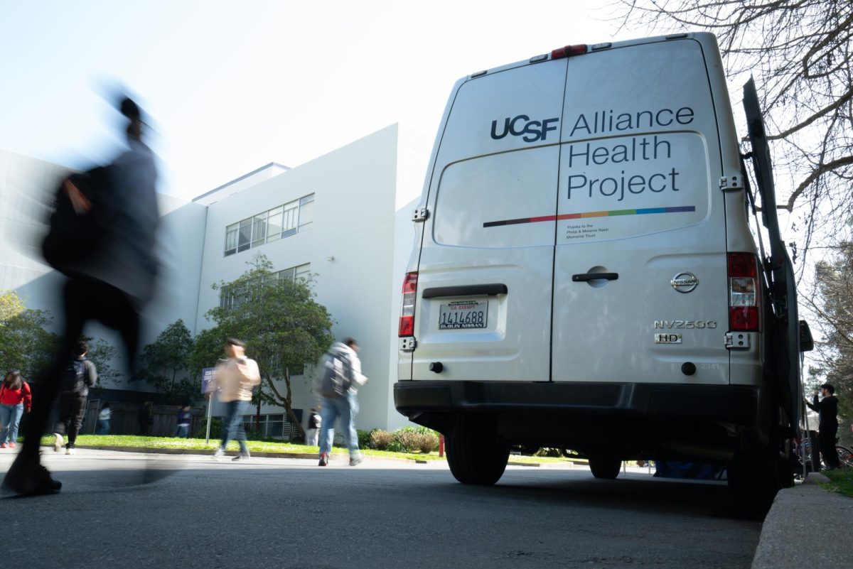 People walk past the UCSF Alliance Health Project van outside of the Student Services building.