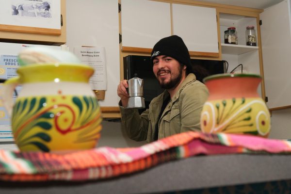 Mario Miranda poses with a coffee maker in the Latinx Student Center. 