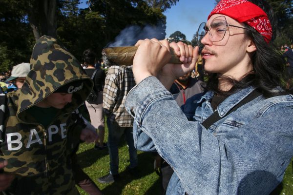 Angel Hancock puts a large joint up to his lips at Hippie Hill in San Francisco, on April 20, 2024. 