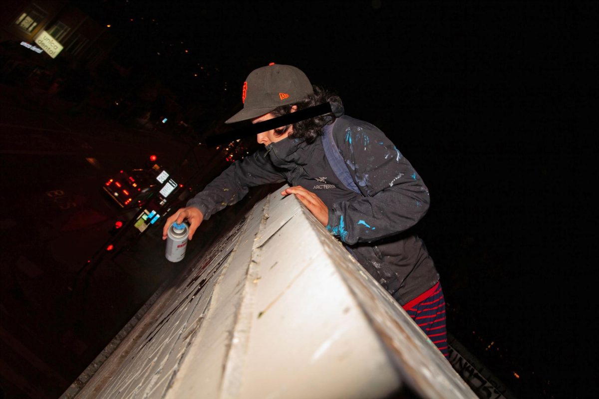 Amsn writes graffiti on the top of a building in the Mission District of San Francisco, Calif., on Thursday, October 04, 2024. (Jesus Arriaga Xpress Magazine) 