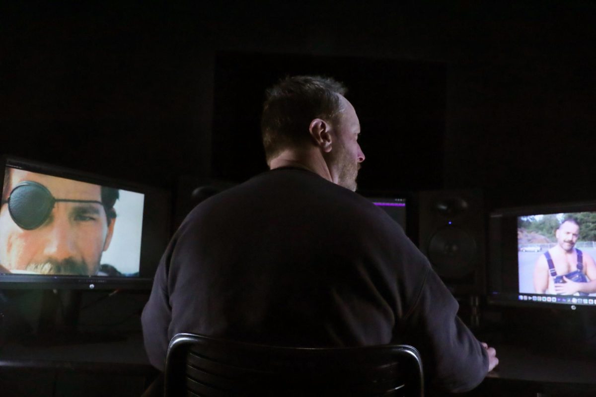 Ryan White looks proudly at his monitor in the editing booth. (Olivia Moran / Xpress Magazine)