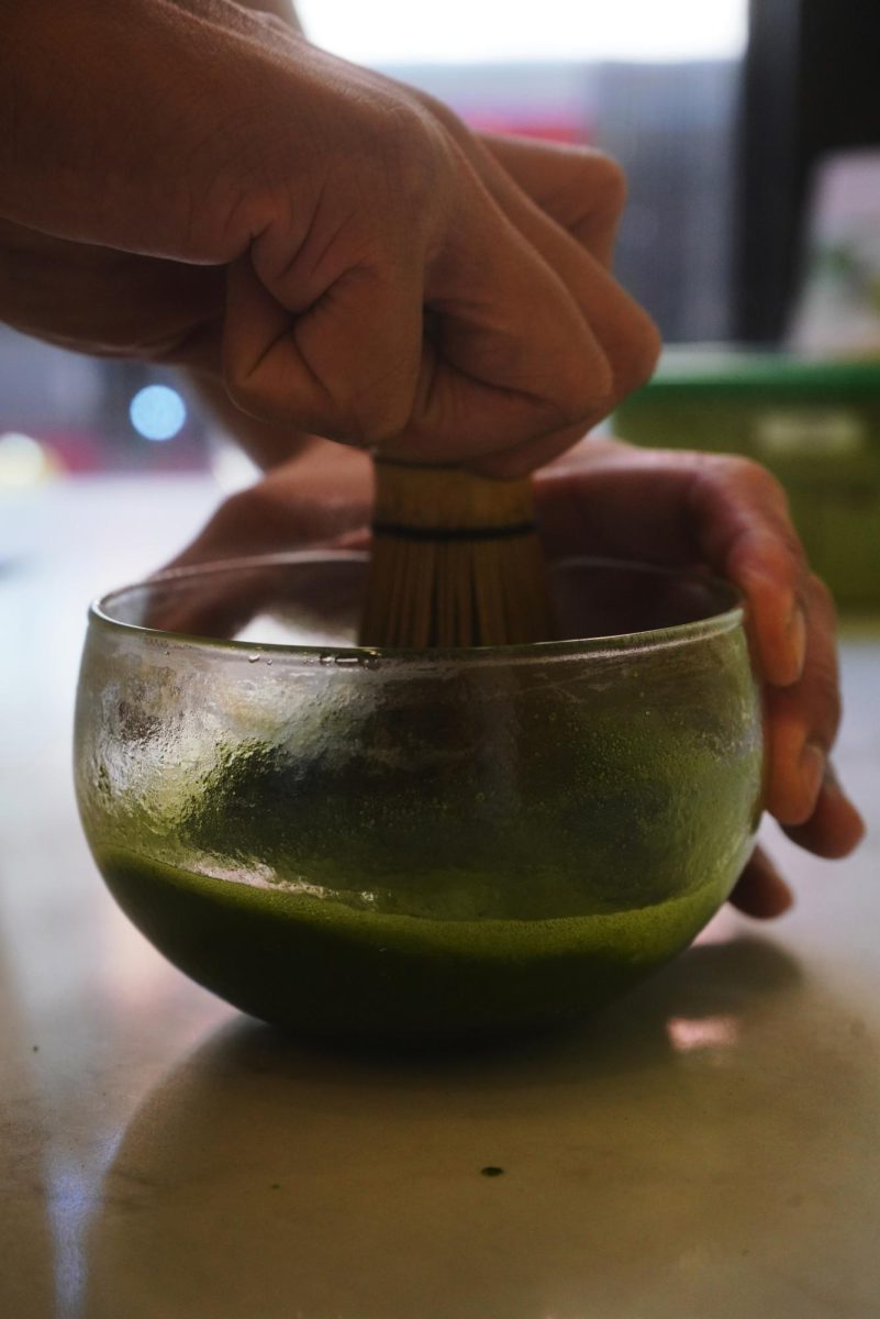 Brian Ng whisking their higher grade matcha with their signature Junbi bamboo and glass matcha bowl. (Lindsey Hoang / Xpress Magazine)