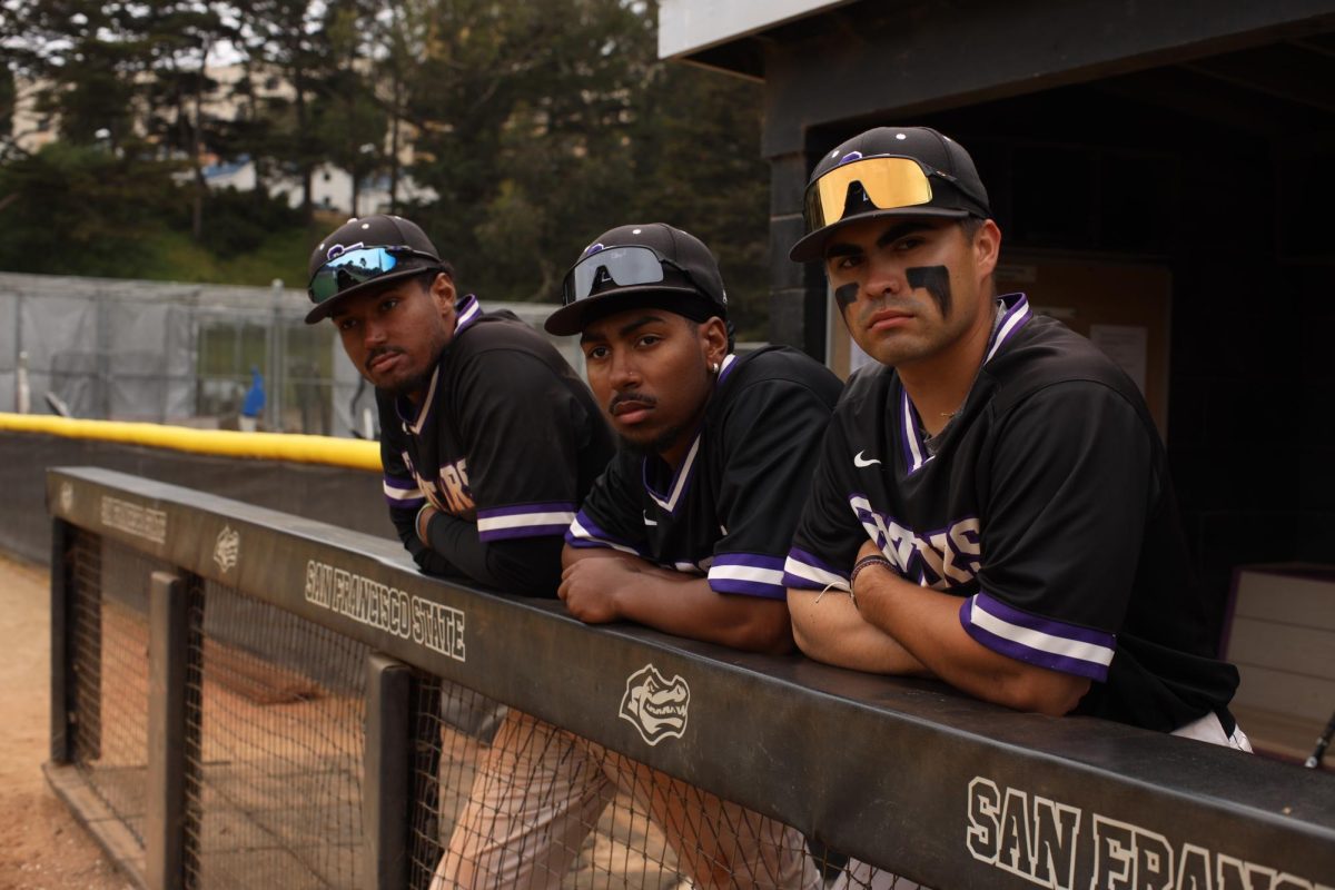 Justin Johnson, Brandon Gaston, and Daniel Santos stand in the dugout at Maloney Field. (Gabriel Carver / Xpress Magazine)