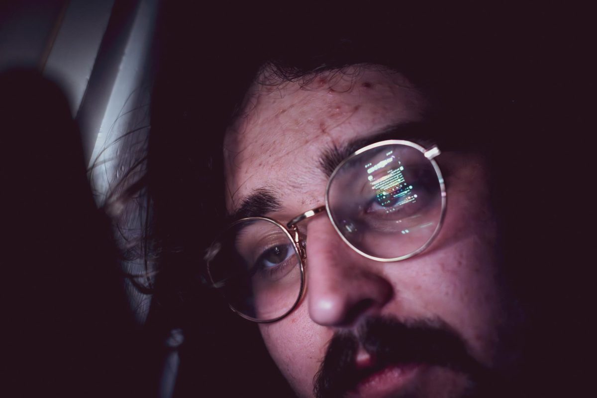 Xpress reporter Ben Rubin reads hateful messages on Yik Yak in response to his request asking for users to share their experiences on the app. (Julian Olson / Xpress Magazine)