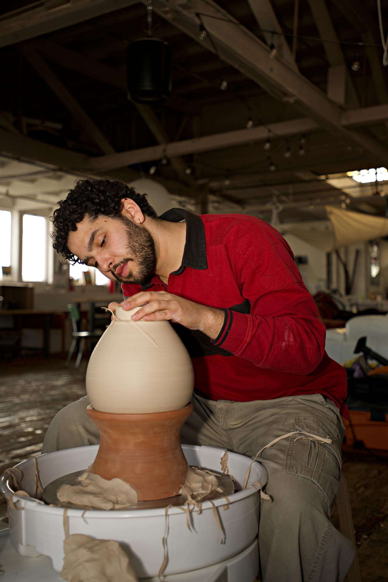 Itai Rinat adjusts an independent ceramic project in the Mud Lab studio space. Rinat is the founder of Mud Lab and teaches the throwing course on Mondays, Wednesdays or Fridays. (Vanden Harris / Xpress Magazine)