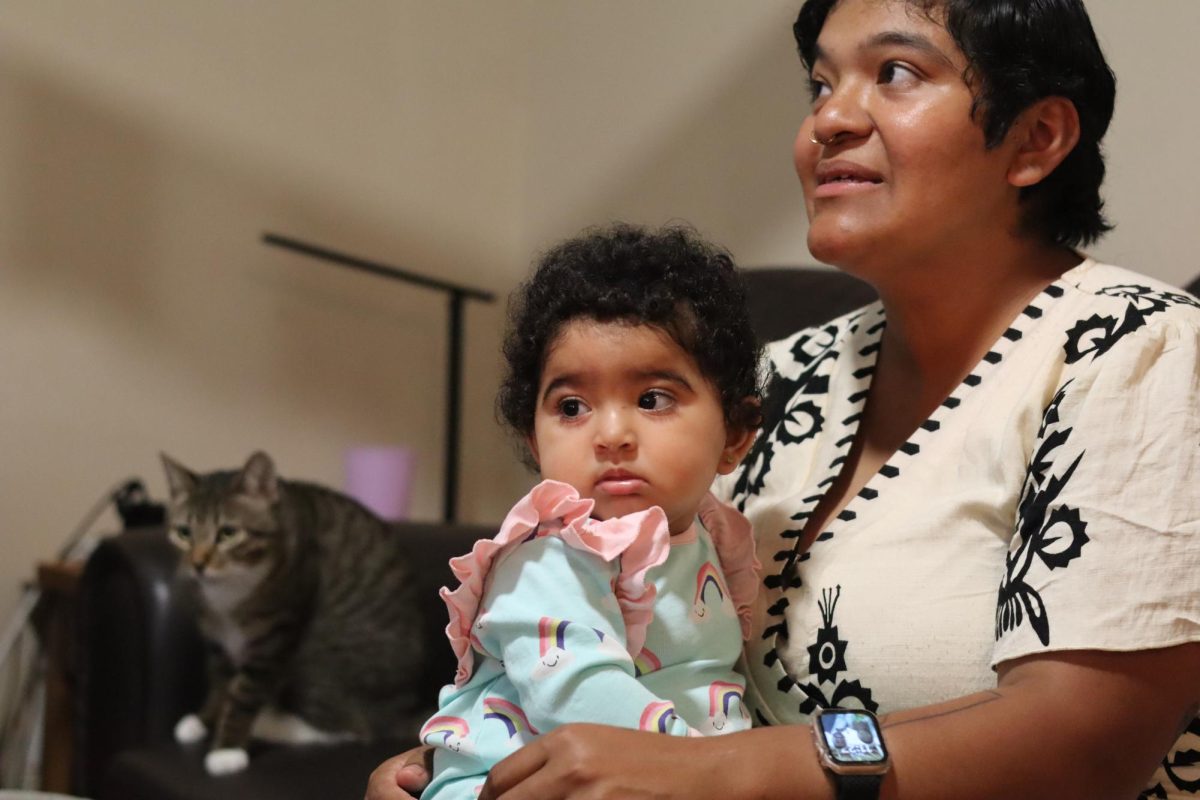Youngest daughter, Joey Carmona, sits on her mom, Laura Jimenez’s lap after waking up from a morning nap on May 7, 2026. (Eliza Arthur / Xpress Magazine)