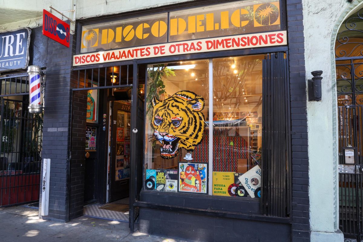 The storefront of Discodelic features a sign reading “discos viajantes de otras dimensiones” hinting at a world of records from other dimensions. (Haley Abarca special to Xpress Magazine)