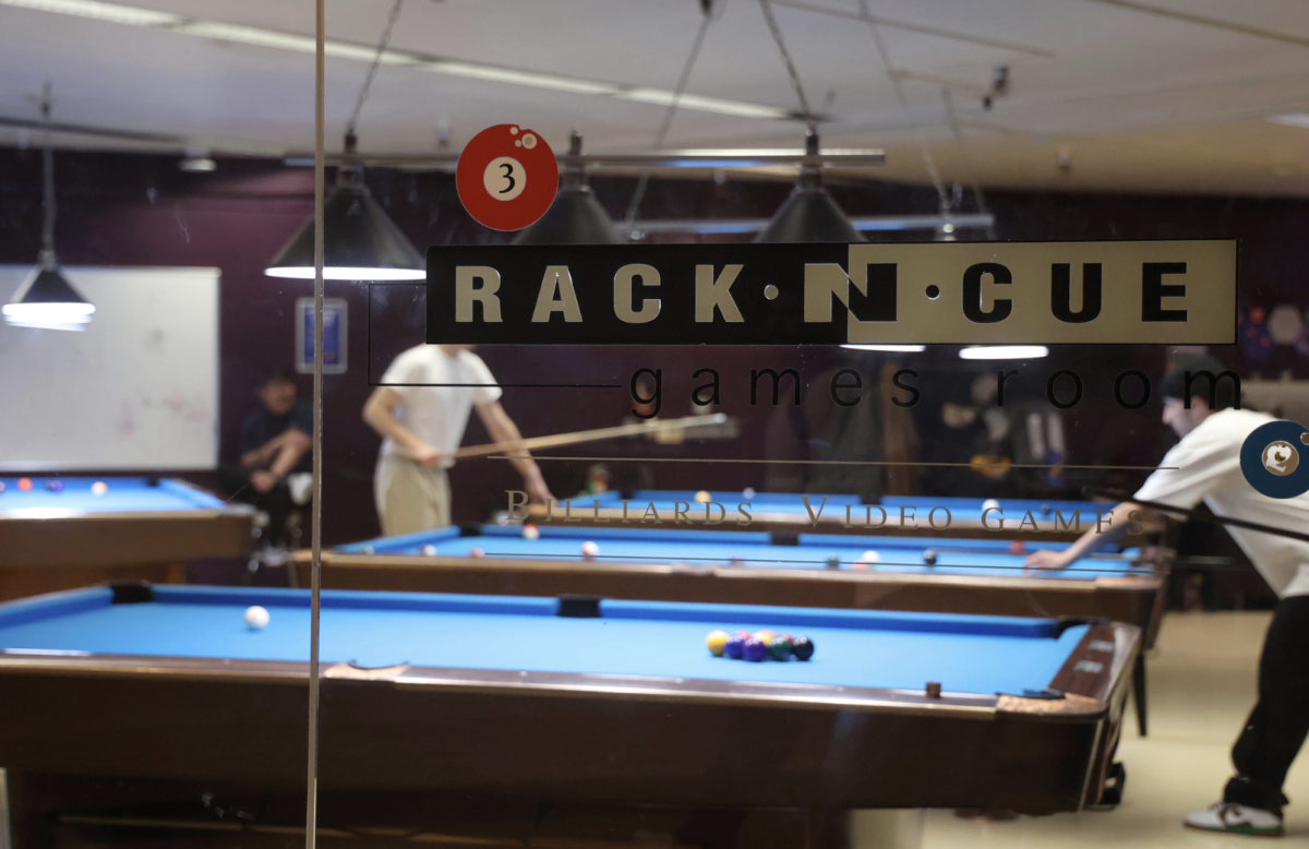 Students play pool in the Rack Cue billiards rooms in the Student Center. (Braelyn Furse / Xpress Magazine)