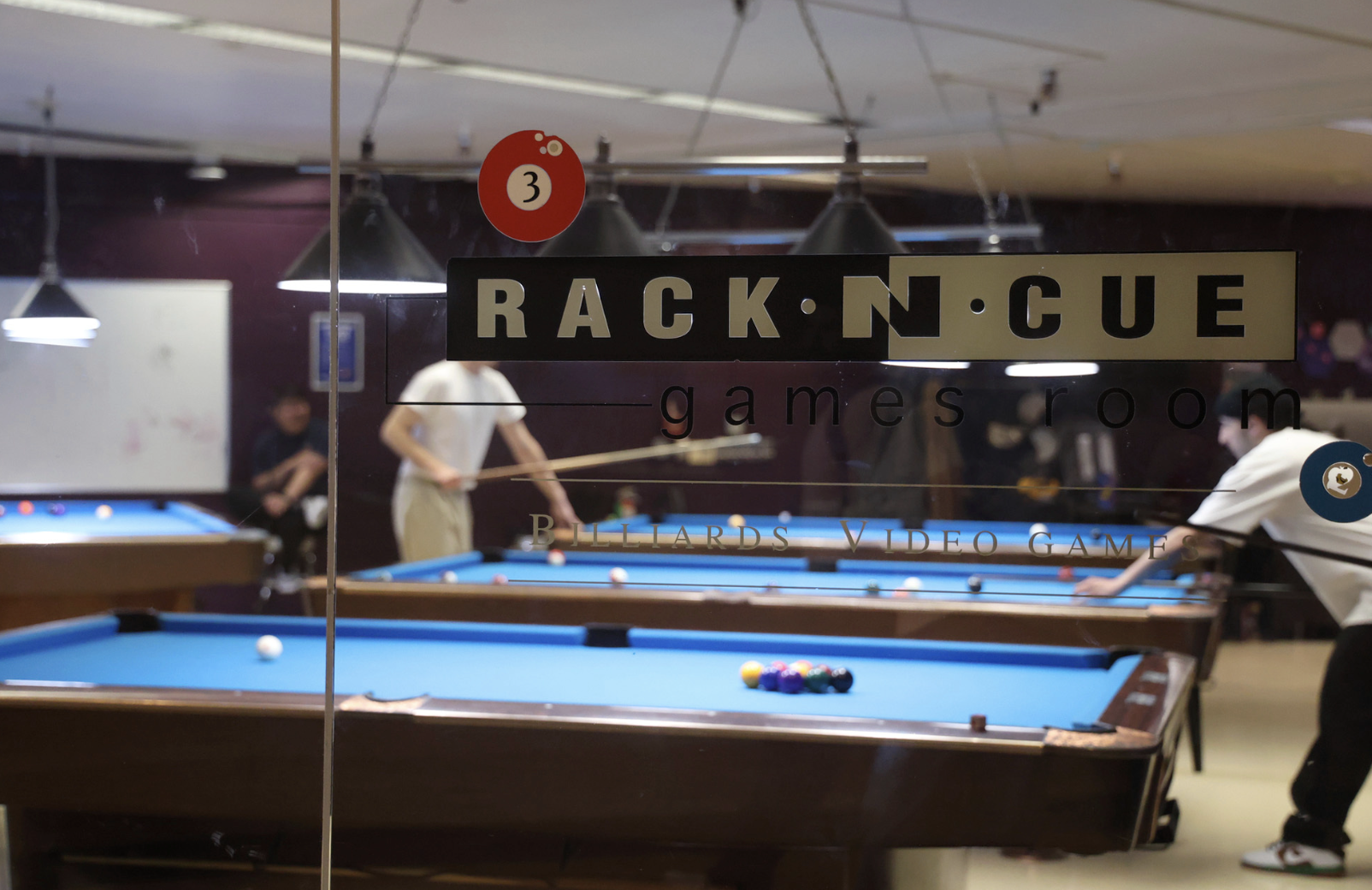 Students play pool in the Rack Cue billiards rooms in the Student Center. (Braelyn Furse / Xpress Magazine)